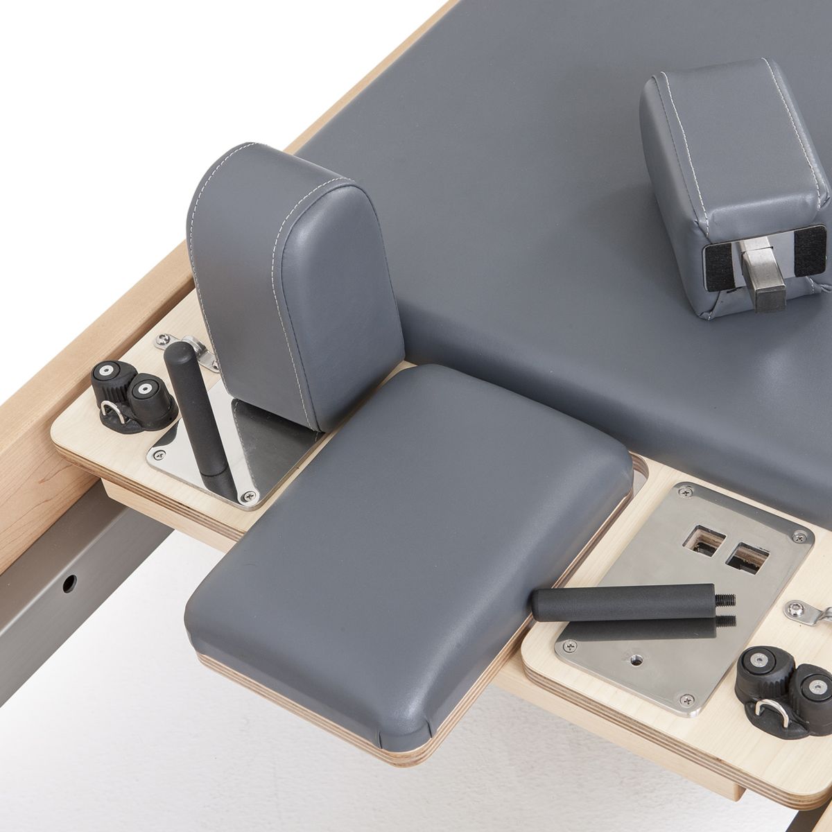 Side view of the Elina Pilates Elite Reformer Bundle highlighting its rock maple wood finish and stainless steel design.