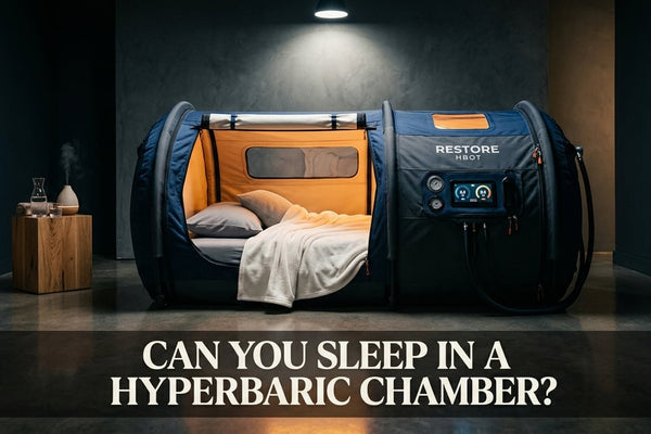 Soft-shell portable hyperbaric chamber with pillow inside, cinematic wellness room setting suggesting sleep use